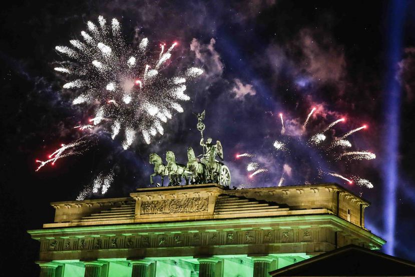 Fuegos artificiales iluminan el cielo sobre la Cuádriga que corona la Puerta de Brandenburgo poco después de medianoche en Berlín. (AP Foto/Markus Schreiber)