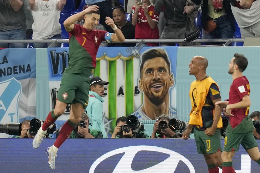 Con una imagen de Lionel Messi en las gradas, Cristiano Ronaldo celebra el gol ante Ghana que lo convirtió en el primer futbolista en anotar en cinco ediciones de Mundiales.