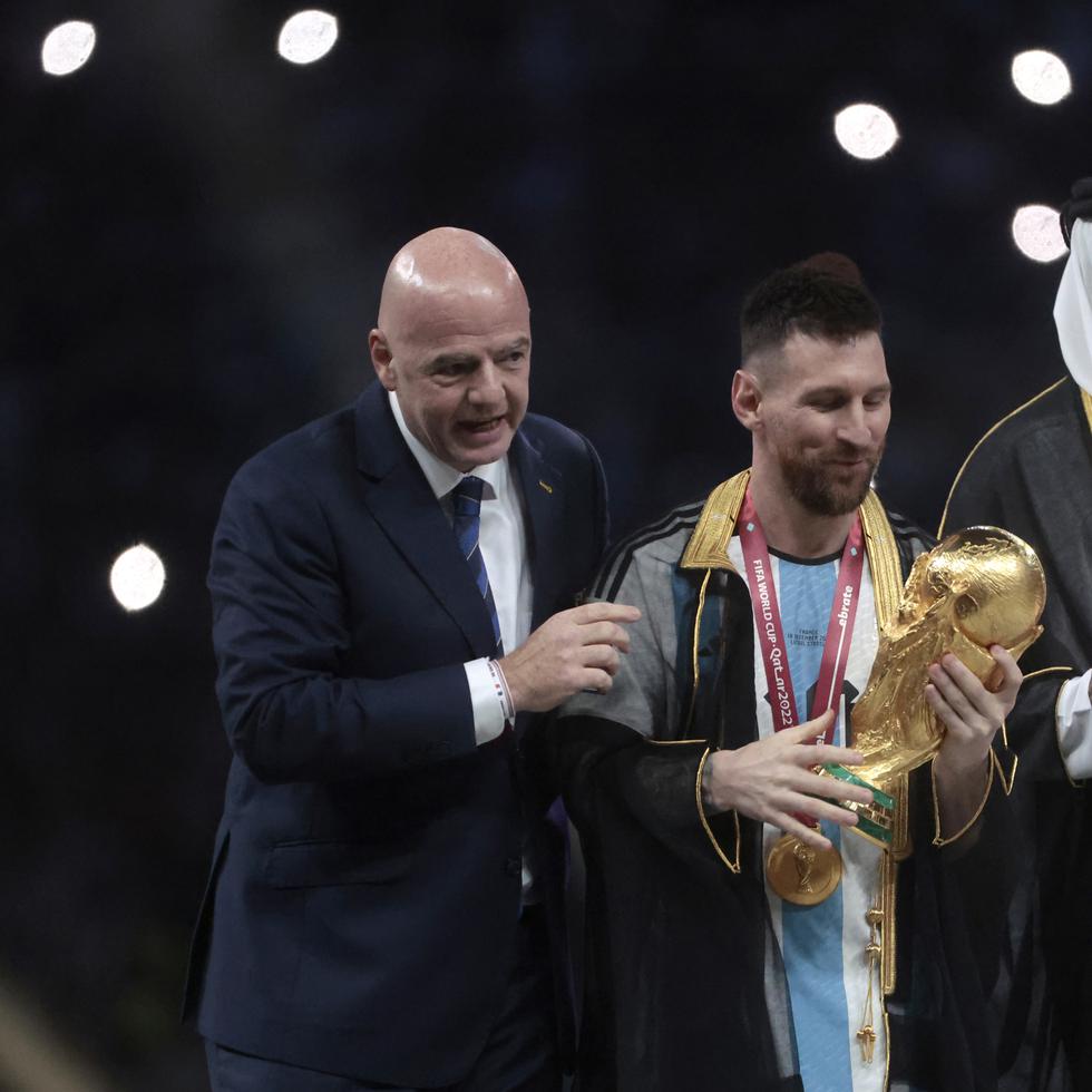 Lionel Messi (centro) posa con el trofeo de la Copa del Mundo junto a el presidente de la FIFA Giovanni Vincenzo (izquierda) y el Emir del Estado de Catar, Tamim bin Hamad Al Thani.