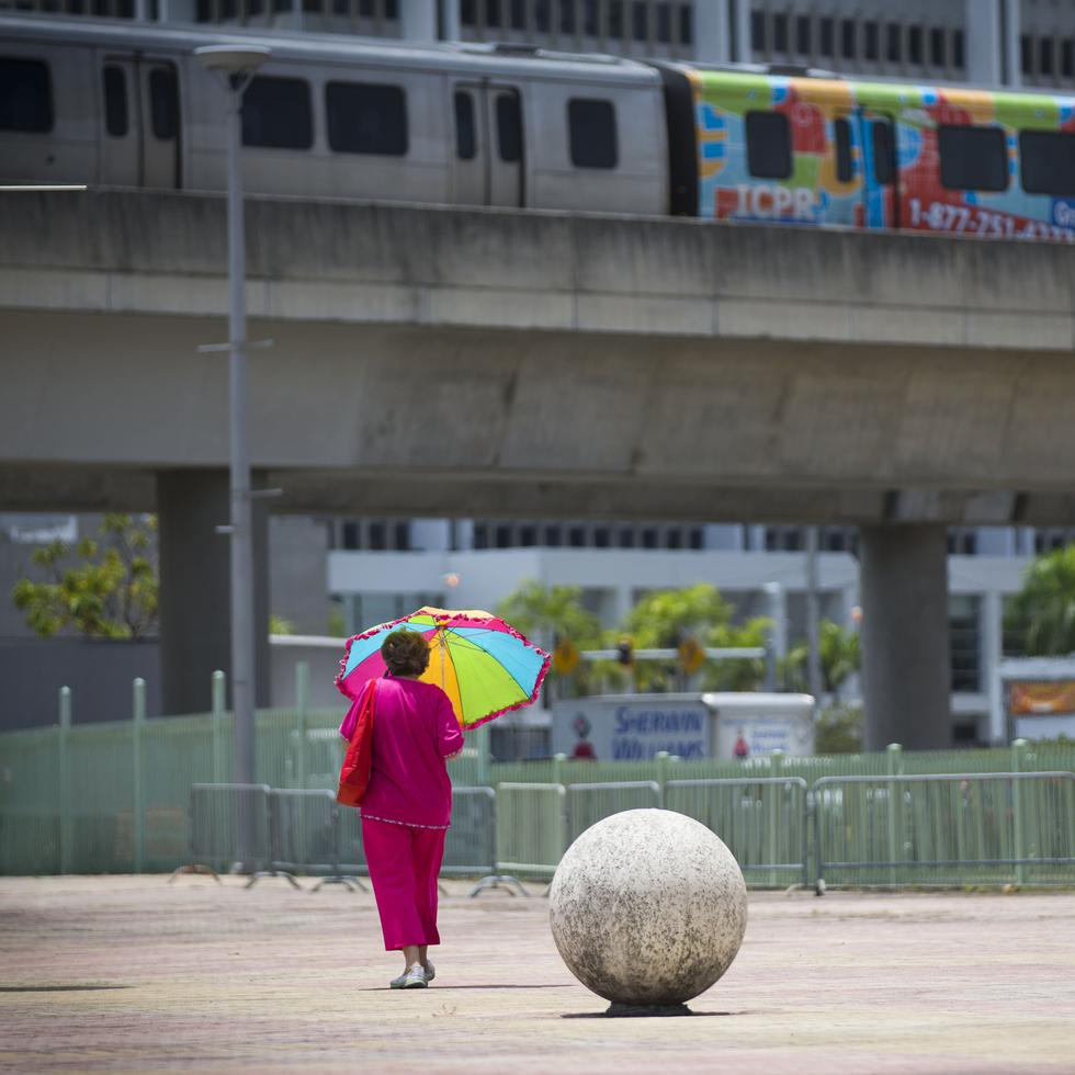 Imagen de archivo de una mujer caminando bajo el sol de mediodía por un área de Hato Rey, San Juan.
