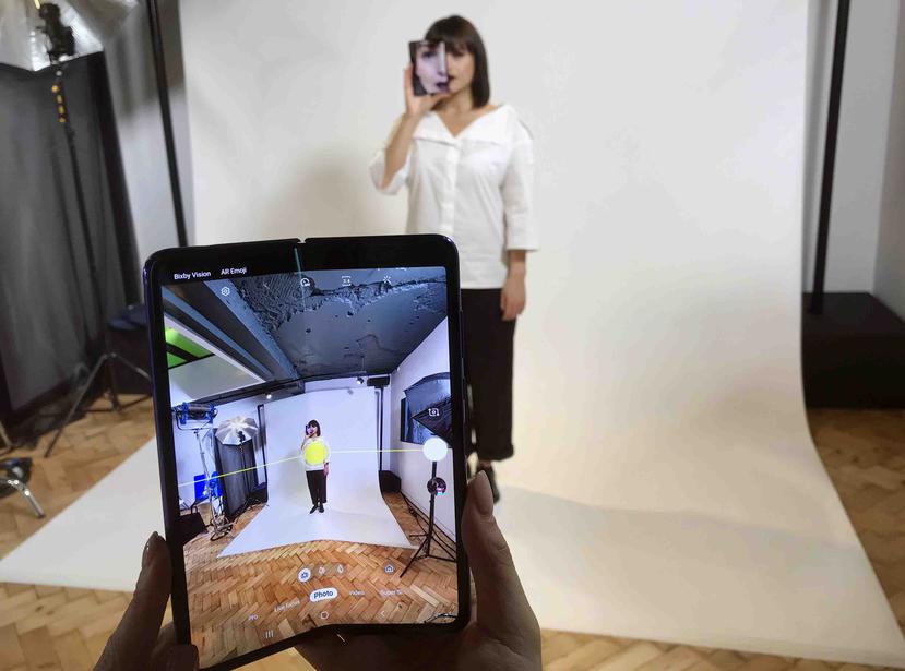 En esta foto del 16 de abril del 2019, una modelo sostiene un Samsung Galaxy Fold junto a su rostro, en un evento con la prensa en Londres. (AP/Kelvin Chan)