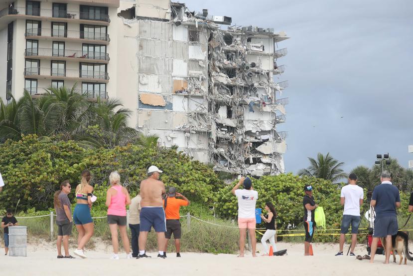 Personas llegan hasta la playa aledaña al condominio Champlain Towers South para ver la magnitud de los daños del colapso.