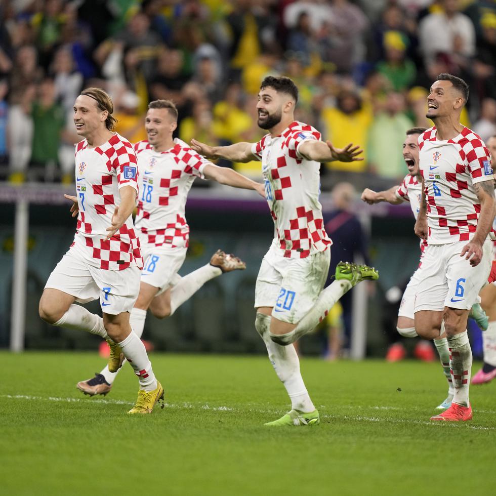 Jugadores de Croacia corren a toda prisa para celebrar el triunfo 4-2 en penales sobre Brasil.