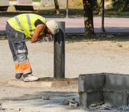 Un trabajador se refresca en una fuente de un parque de Lleida, este viernes en que todas las comarcas de Cataluña entran en el máximo nivel de alerta por la ola de calor.