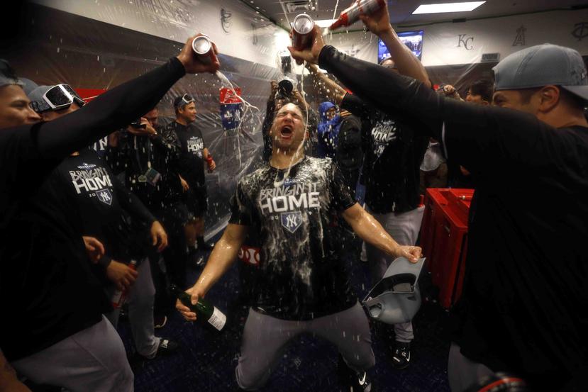 Los jugadores de los Yankees celebran su victoria en el camerino. (AP)