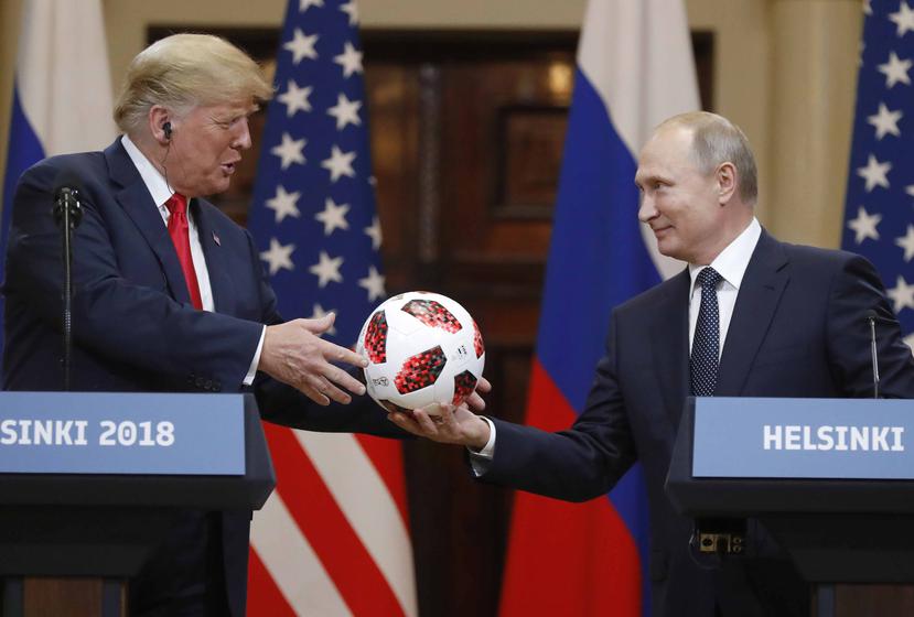 Trump recibe un balón de fútbol de manos del presidente ruso Vladimir Putin. (AP)