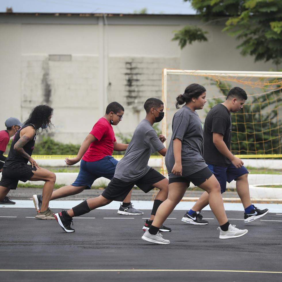 Varios de los jóvenes y la entrenadora Keren Canales se ejercitan durante uno de los entrenamientos en la cancha de balonmano de Naguabo.