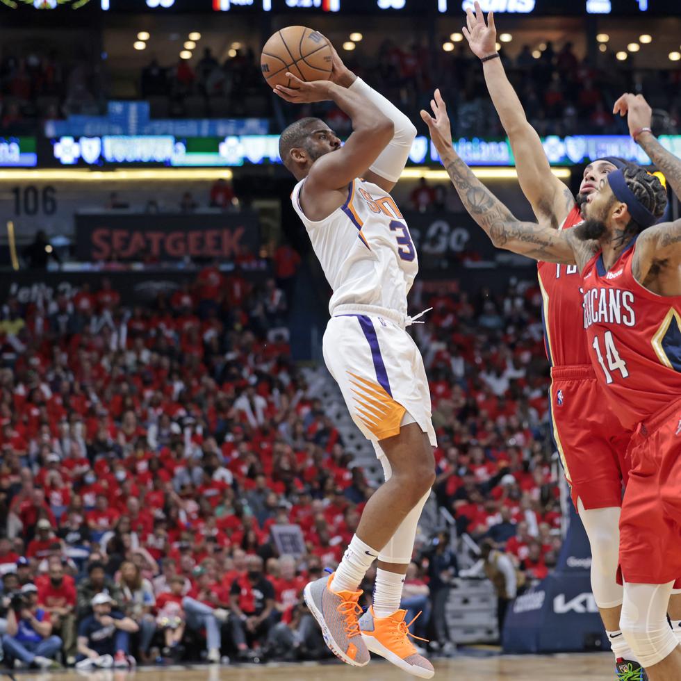 Chris Paul, de los Suns de Phoenix, tira al canasto con dos jugadores encimados de los Pelicans de Nueva Orleans.
