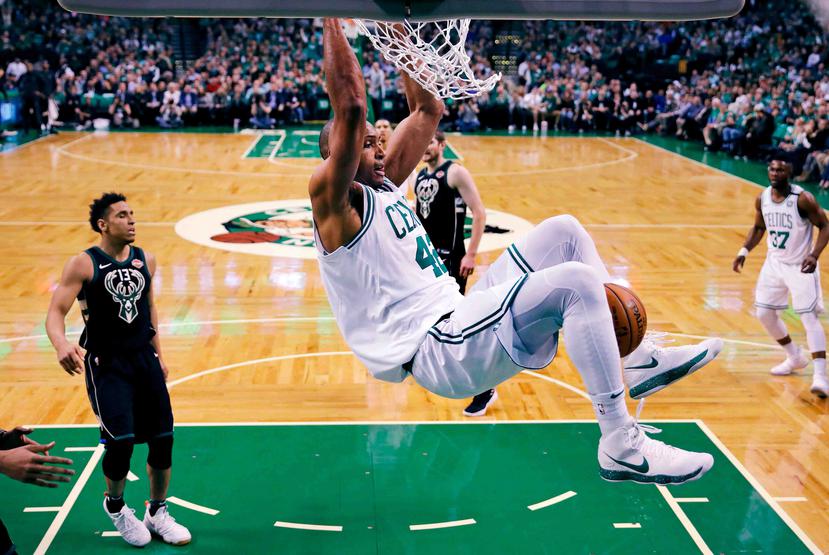 El dominicano Al Horford, de los Celtics de Boston, se cuelga del aro tras realizar una clavada en el quinto juego de la serie de playoffs ante los Bucks de Milwaukee. (AP)