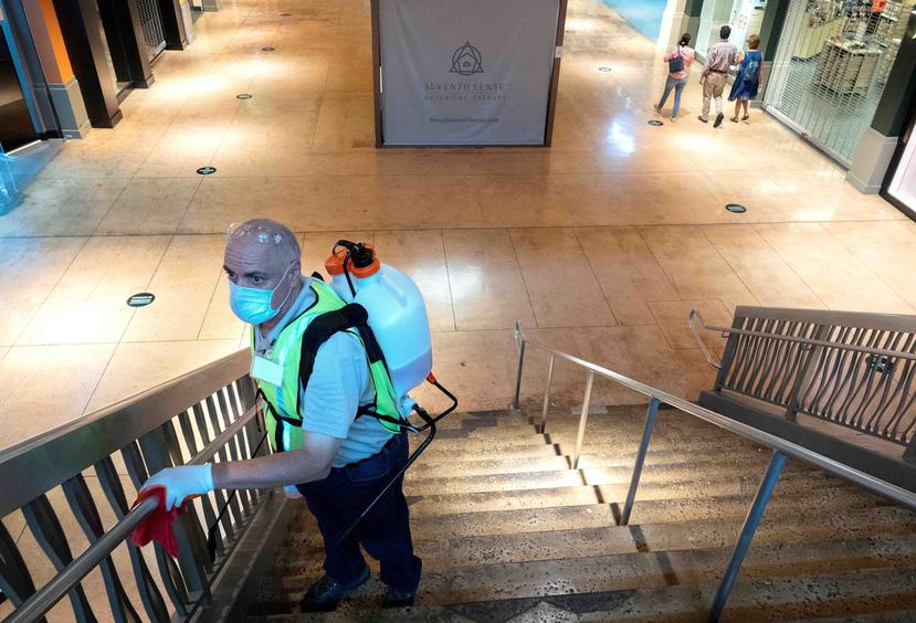 Un empleado limpia las escaleras del centro comercial Dolphin en Miami. (EFE)