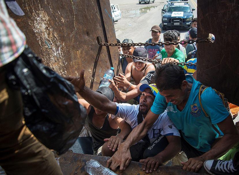 Integrantes de la caravana de migrantes intentan subir a un vehículo, en México (EFE / Luis Villalobos)