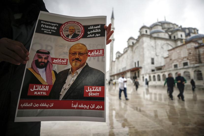 Una persona sostiene un cartel que muestra imágenes del príncipe heredero saudí Muhammed bin Salman y del periodista Jamal Khashoggi, en el que se describe al príncipe como "asesino" y a Khashoggi como "mártir". (AP)