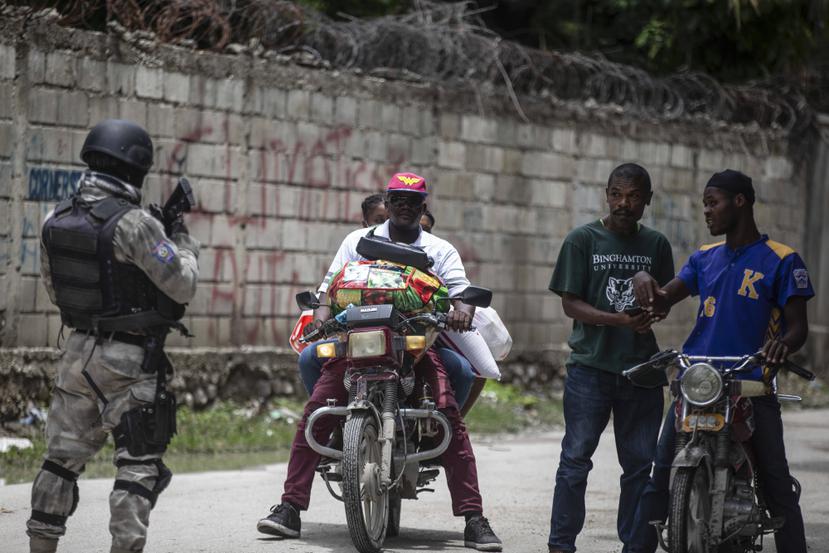 Un policía vigila una calle durante un operativo antipandillas el jueves 28 de abril de 2022, en Croix-des-Missions, al norte de Puerto Príncipe, Haití.