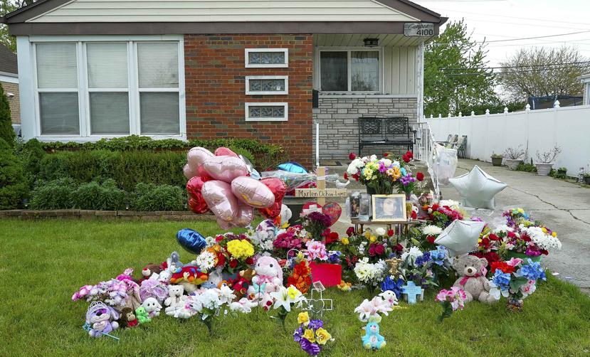 Personas dejan flores en las afueras de la casa donde Marlen Ochoa-López fue asesinada. (AP)