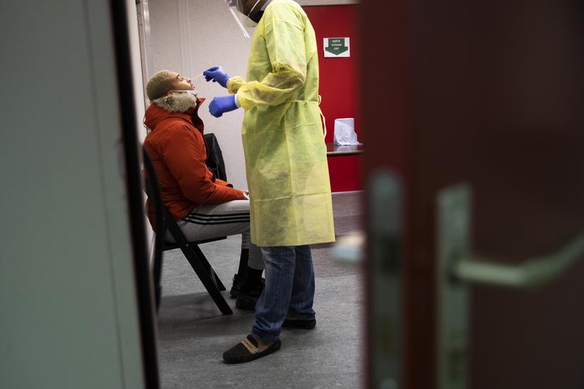 Un trabajador de la Cruz Roja toma una muestra para una prueba molecular de COVID-19.