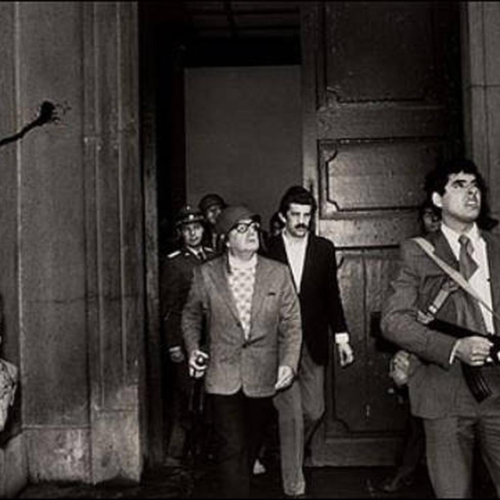 GOLPE DE ESTADO CHILE 1974: SANTIAGO DE CHILE, 11-9-73.- EL PRESIDENTE CHILENO SALVADOR ALLENDE ,CON UN CASCO EN LA CABEZA Y ARMADO CON UN RIFLE, EN LA PUERTA DEL PALACIO DE LA MONEDA DURANTE EL ASALTO DEL EJERCITO.. LE ACOMPAÑAN SUS GUARDAESPALDAS Y SU MEDICO PERSONAL, DANILO BARTULIN. ULTIMA FOTO DE ALLENDE, QUE MURIO ESE DIA. FUE CAPTADA POR UN FOTOGRAFO NO IDENTIFICADO Y PRESENTADA POR EL NEW YORK TIMES AL CONCURSO ORGANIZADO POR LA FUNDACION WORLD PRESS PHOTO, QUE LE CONCEDIO EL PREMIO FOTO DE PRENSA DE 1973.
