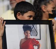 Un niño sujeta una la foto de Angeliris Marrero, joven boricua embarazada que fue asesinada en República Dominicana por su pareja y que fue enterrada hoy en Canóvanas.