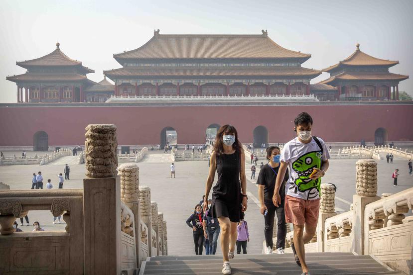 Visitantes usan mascarillas para visitar la Ciudad Prohibida de China. (AP)