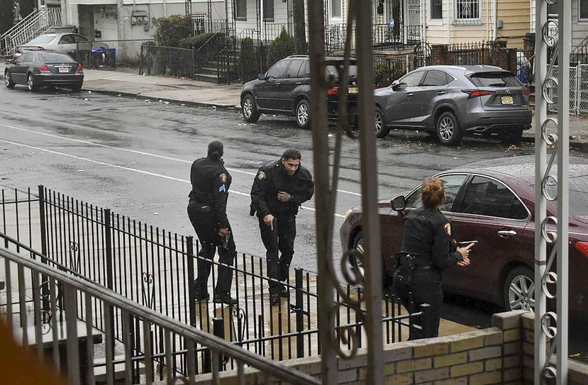 La foto muestra al oficial Raymond Sánchez, quien es asistido por dos compañeros luego de ser herido durante el tiroteo en Nueva Jersey del 10 de diciembre. (Justin Moreau vía AP)