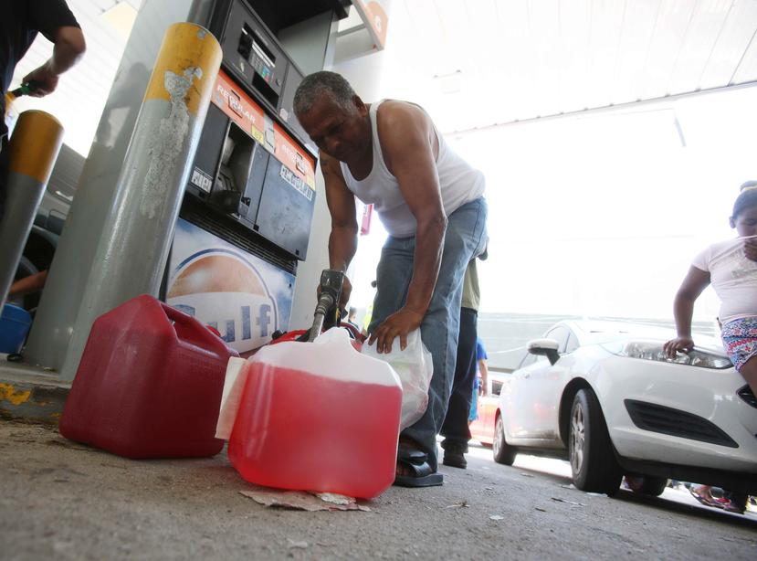 Un hombre llena varios recipientes de gasolina. (GFR Media)