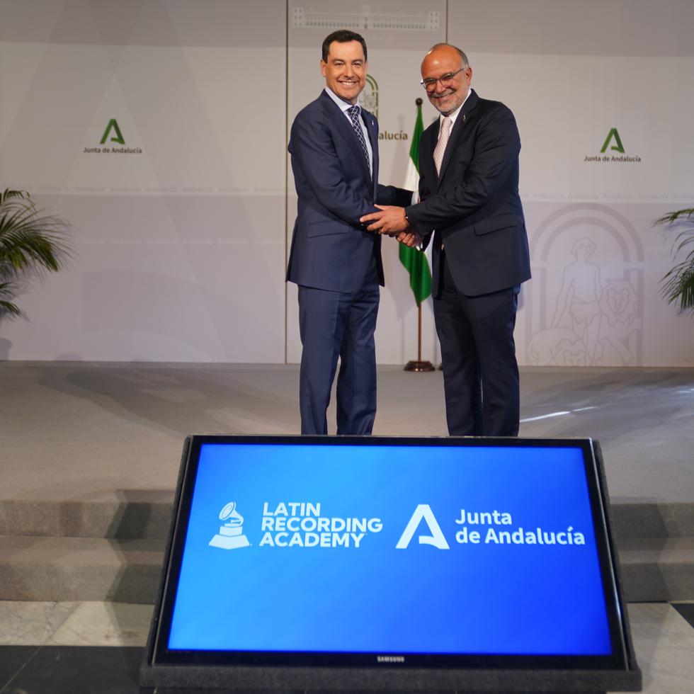 Juanma Moreno, a la izquierda,  presidente regional de la Andalucía, le da la mano a Manuel Abud, ejecutivo principal de la Academia Latina de Grabación, luego de anunciar el acuerdo para celebrar los Latin Grammy en la ciudad de Sevilla hasta el 2025.