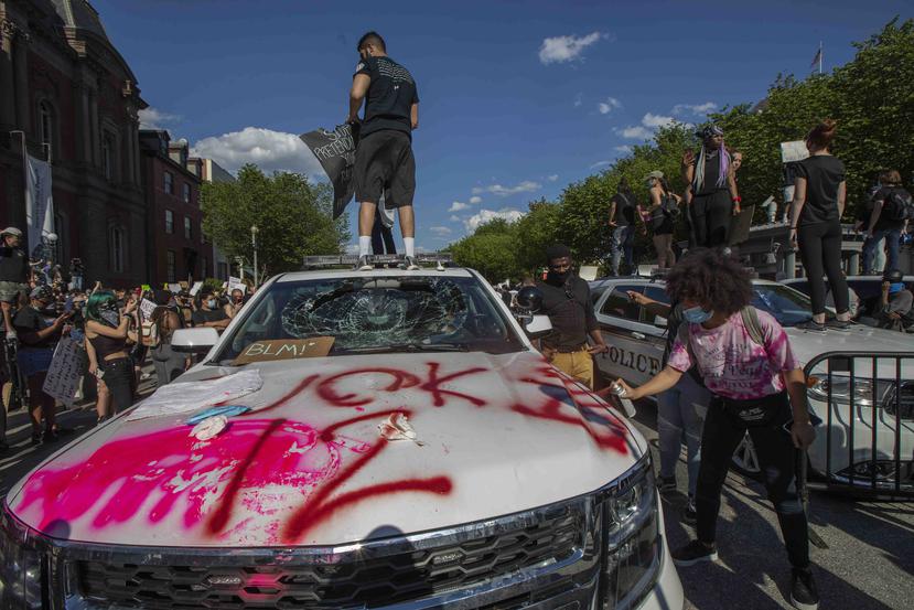 Manifestantes vandalizan un vehículo del Servicio Secreto frente a la Casa Blanca. (AP)