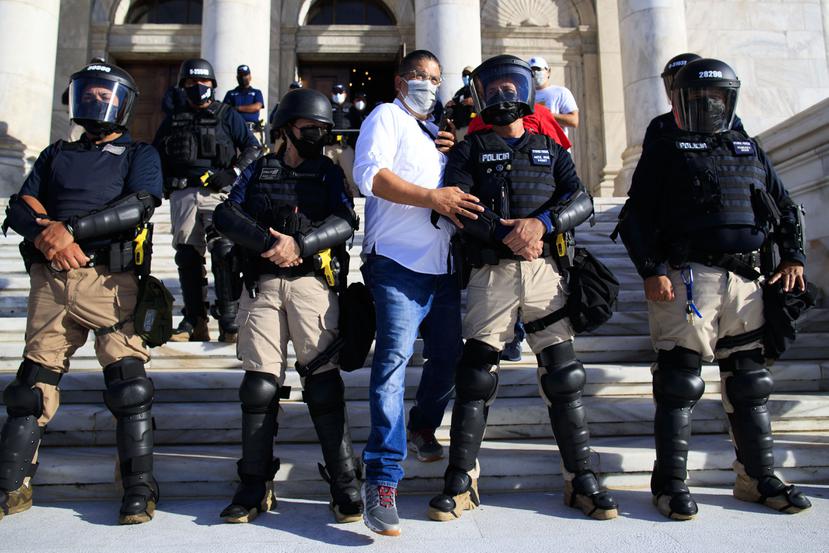 Tatito Hernández cruza la línea de policías durante manifestación por el contrato de LUMA, en el Capitolio.