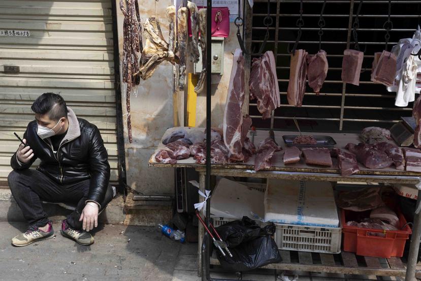 En esta foto del viernes, 3 de abril del 2020, un vendedor espera como clientes en un estante cerca de un mercado aún parcialmente cerrado por el brote de coronavirus en Wuhan, en el centro de China. (AP Foto/Ng Han Guan)