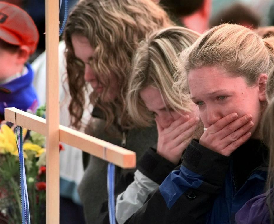 Esta foto de archivo, del 22 de abril de 1999, muestra a familias llorando la muerte de las víctimas en el tiroteo de la escuela secundaria Columbine.