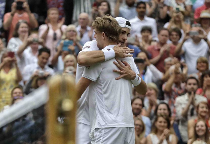 Kevin Anderson (der) se abraza con John Isner después de ganar el partido más largo de la historia en la cancha central del All England Club. (AP)