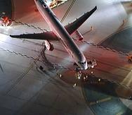 Un avión de American Airlines es examinado el sábado 11 de febrero de 2023 tras chocar la víspera con un autobús de enlace, en el aeropuerto internacional de Los Ángeles. (KABC vía AP)