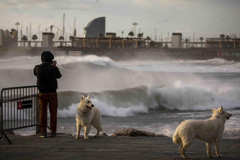 Un hombre toma fotografías del mar Mediterráneo en Barcelona. (AP)