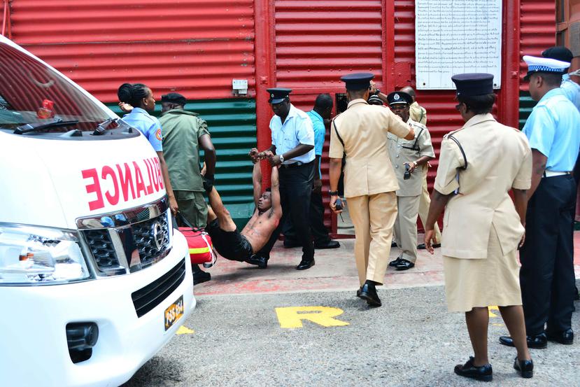 Autoridades policiales y militares sacan a un reo de la cárcel Camp Street en Georgetown, Guyana. (EFE / Samuel Maughn)
