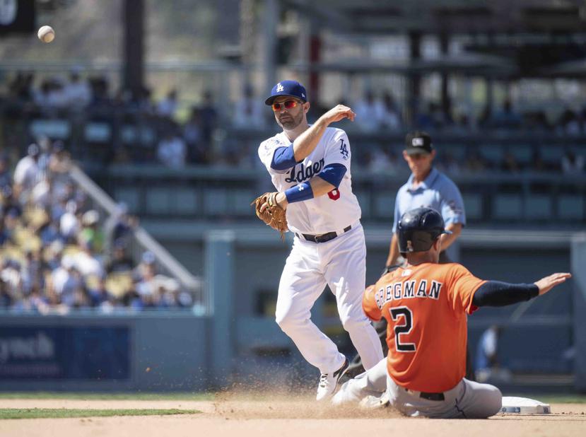 El segunda base de los Dodgers, Brian Dozier, ejecuta un doble play ante Alex Bregman. (AP)