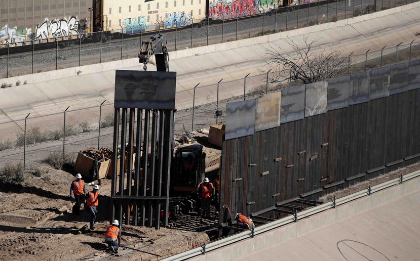 Unos trabajadores colocan unas secciones de valla metálica mientras construyen un nuevo muro a lo largo de la frontera entre Texas y México, cerca del centro de El Paso. (AP)
