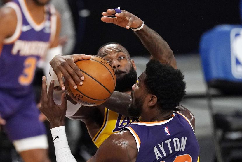 LeBron James de los Lakers detiene un tiro de Deandre Ayton de los Suns de Phoenix.