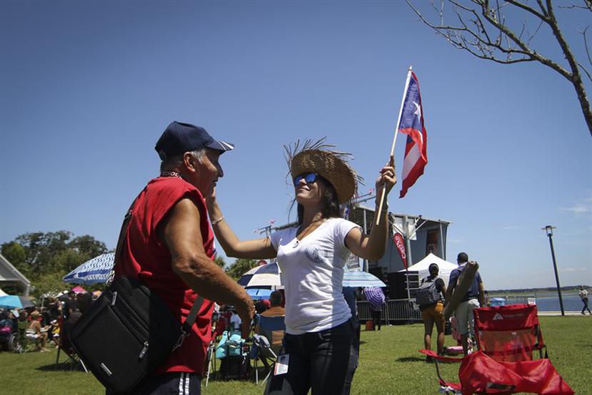 Magda Reyes y Jorge Vélez bailando con la bandera de Puerto Rico en el Desfile Puertorriqueño en Kissimmee (Ángel M. Rivera / Especial para Primera Hora)