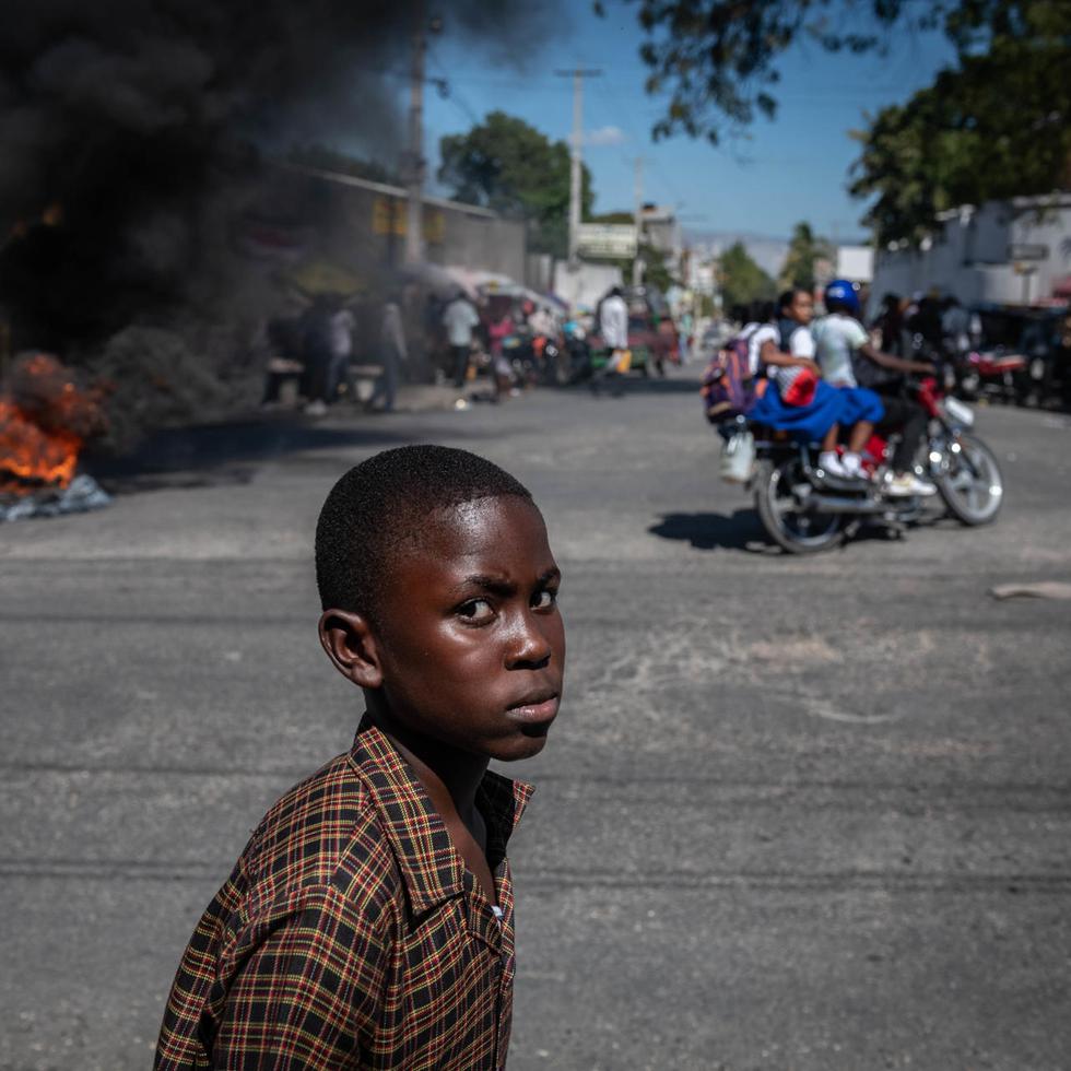 Un niño camina por una calle con bloqueos en el marco de las protestas, en Puerto Príncipe, Haití, el 26 de enero de 2023. EFE/Johnson Sabin