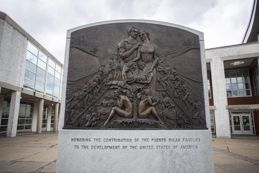 La foto muestra un monumento dedicado a las familia puertorriqueñas que aportaron y aportan al desarrollo de los Estados Unidos. El monumento está ubicado en la esquina de las calles Vernon y Washington en Hartford.
