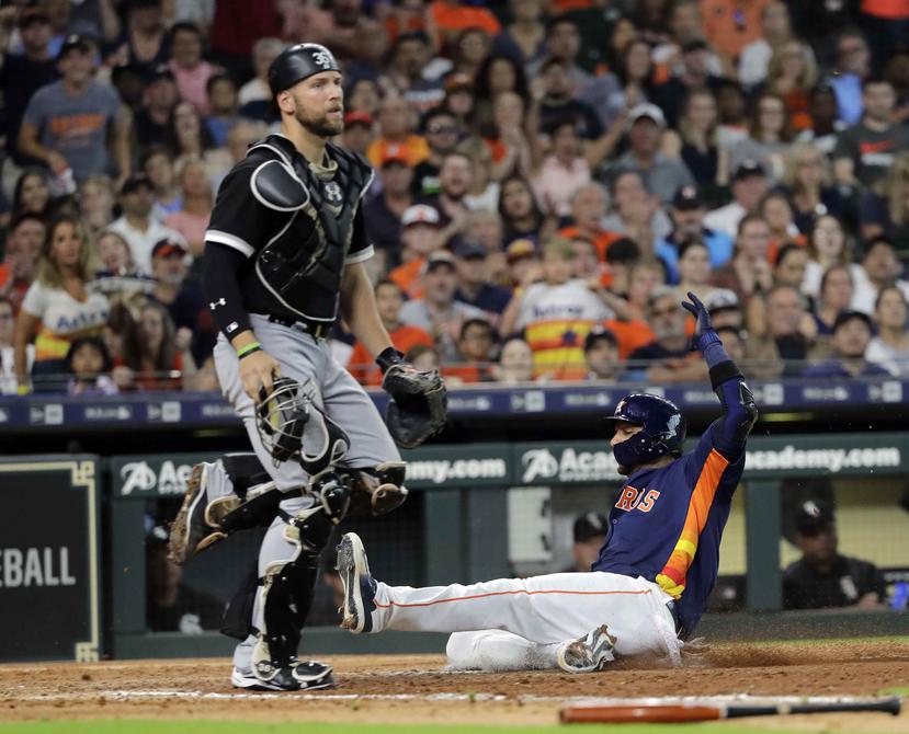 El jugador de los Astros de Houston, Yuli Gurriel, se barre para anotar tras un toque de sacrificio del venezolano Marwin González durante el séptimo inning de un juego de béisbol el domingo 8 de julio de 2018, en Houston. (AP)
