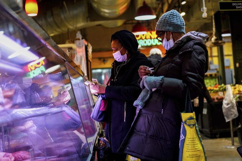 ARCHIVO - Dos mujeres portan mascarillas en un mercado para protegerse del COVID-19, el 16 de febrero de 2022, en Filadelfia. (AP Foto/Matt Rourke, archivo)