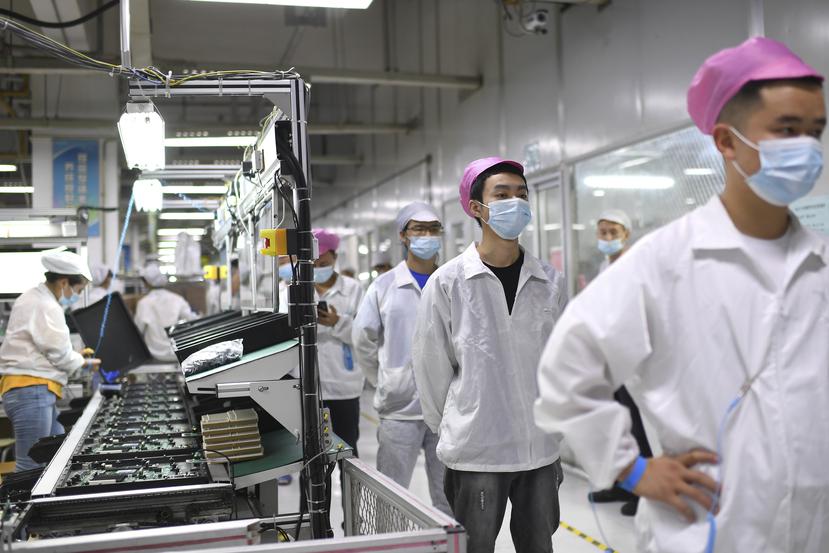 Imagen de archivo de trabajadores se forman para someterse a una prueba de coronavirus en una fábrica de Wuhan, China.