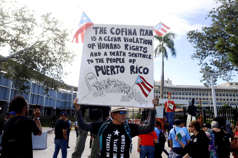 Un hombre sostiene una pancarta durante una manifestación convocada hoy ante el Tribunal Federal en San Juan. (Agencia EFE)