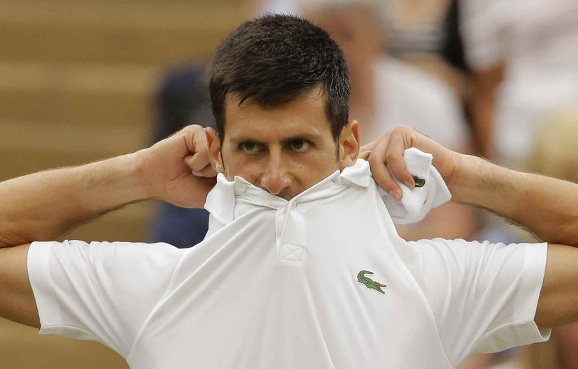 Novak Djokovic se cambia la camisa durante el partido ante Adrian Mannarino. (AP)
