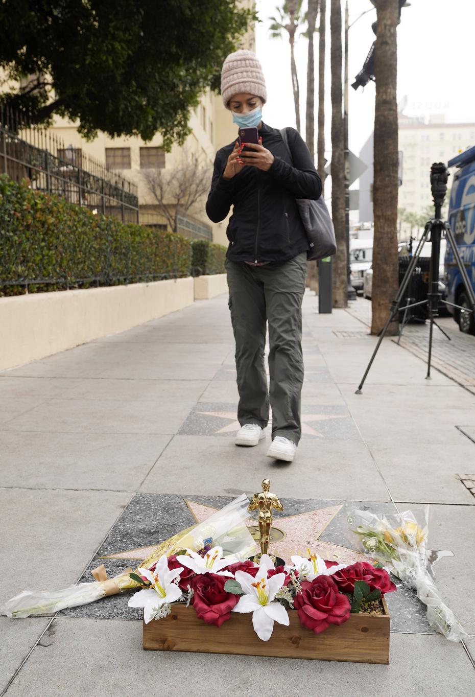 La actriz Tanya Young of Los Angeles toma una fotografía a la estrella del fenecido actor en el Paseo de la Fama de Hollywood. (AP Photo/Chris Pizzello)