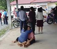 En esta imagen, tomada de un video, muestra a una mujer que recibe consuelo en el exterior de un jardín de infantes donde se registró una balacera, en Nongbua Lamphu, en el noreste de Tailandia.