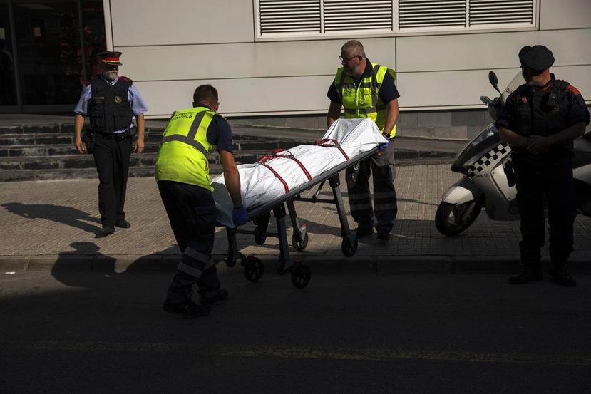 Operarios retiran un cadáver en una camilla, en el exterior de una comisaría de Policía tras un ataque en Cornella de Llobregat, cerca de Barcelona. (AP / Emilio Morenatti)