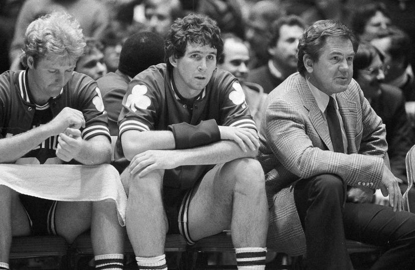 En esta foto de archivo del 21 de diciembre de 1982, el entrenador de los Celtics de Boston, Bill Fitch, y los jugadores Rick Robey, centro, y Larry Bird observan desde la banca mientras su equipo pierde 122-105 ante los 76ers de Filadelfia. (AP/Peter Mor