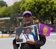 Un seguidor del expresidente dominicano Leonel Fernández muestra imágenes del exmandatario, durante una manifestación en Santo Domingo. (EFE)