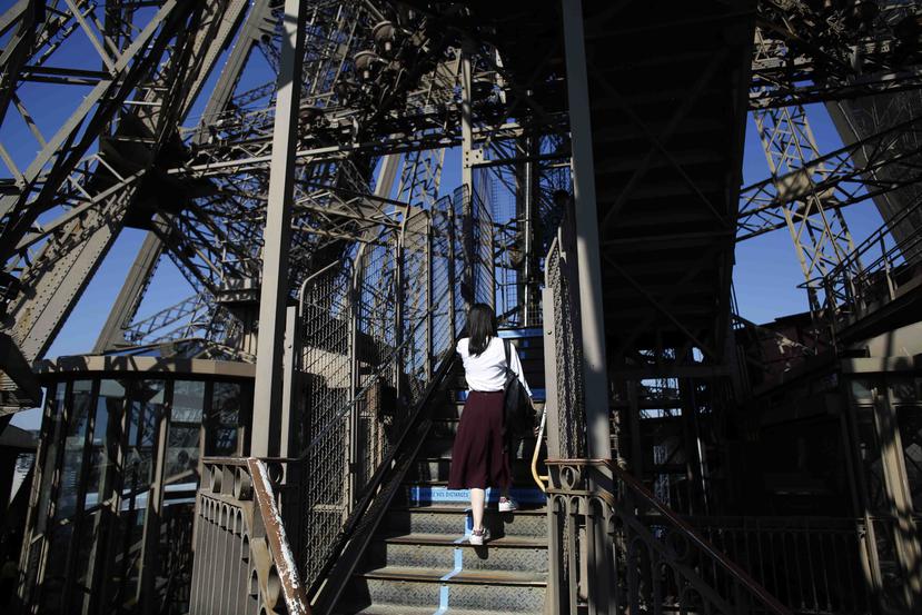 Una visitante sube las escaleras de la Torre Eiffel el día de su reapertura. (AP)